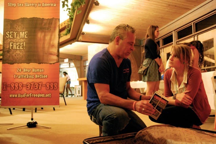 Pastor Pasco Manzo and 21-year-old elementary education senior Christa Goad unpack brochures at A Night of Rescue. Goad planned this event to inform students about the human sex trafficking epidemic happening in America and to raise money for Manzo's organization, Run for Freedom.