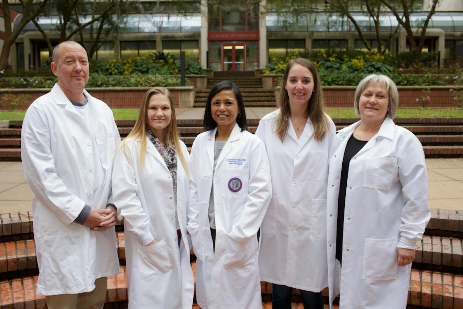 Catherine Flores (middle) stand with other members of the UF Brain Tumor Immunotherapy Program. As principal investigator of the program, Flores researches how to fight brain tumors in children.