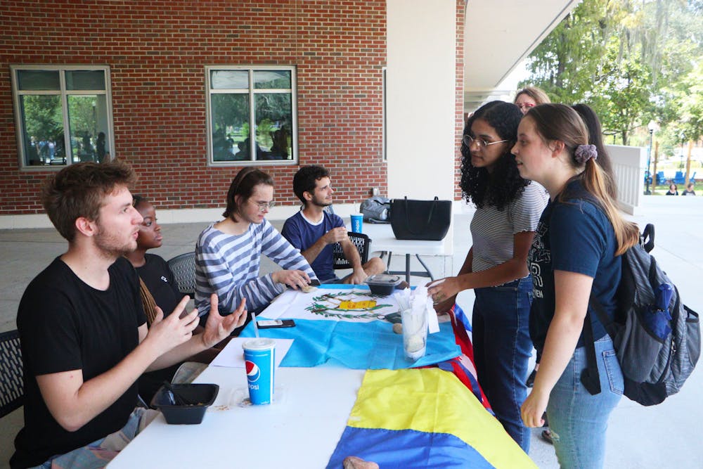 <p>The Davis United World College Scholars talk to students while tabling outside the Reitz Union on Wednesday, Sep. 21, 2022.</p>