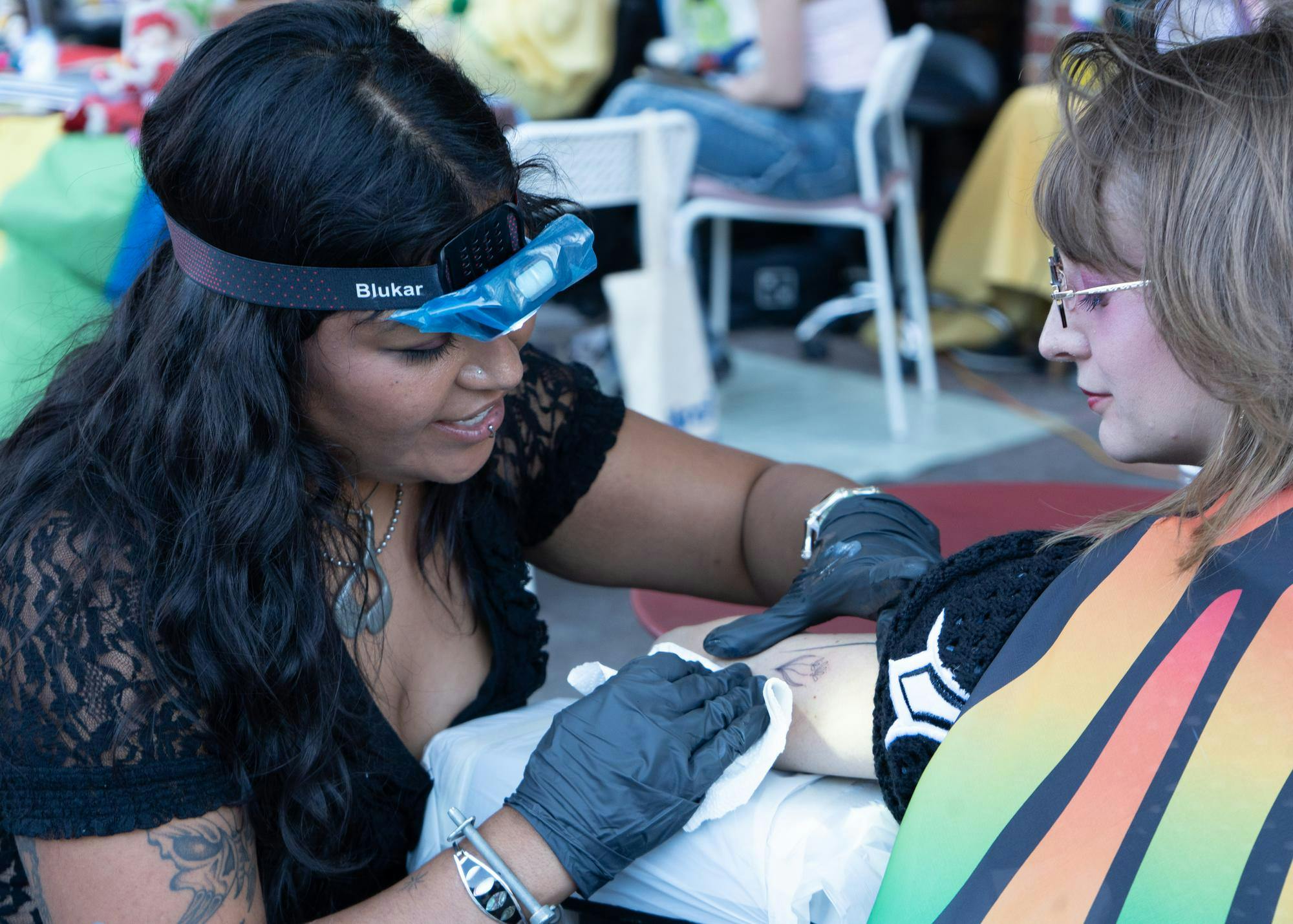 Johmaris Ramos (Princesa Poke) tattoos festival goers on the streets at Big Culture & Arts Festival on Saturday, April 11, 2026.