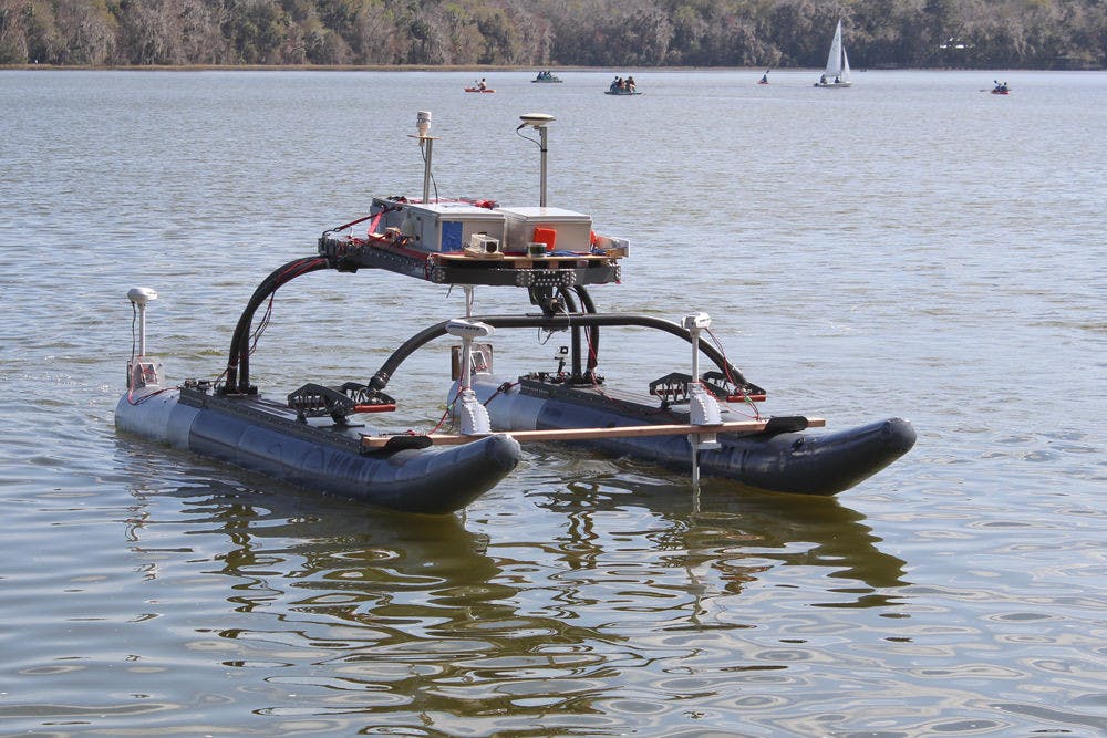 NaviGator, a self-steering boat built by a team of 10 UF students, cruises on Lake Wauberg on Saturday. Built at the UF Machine Intelligence Lab with a $250,000 grant, the boat senses its environment using radar and makes navigational decisions based on what it detects.