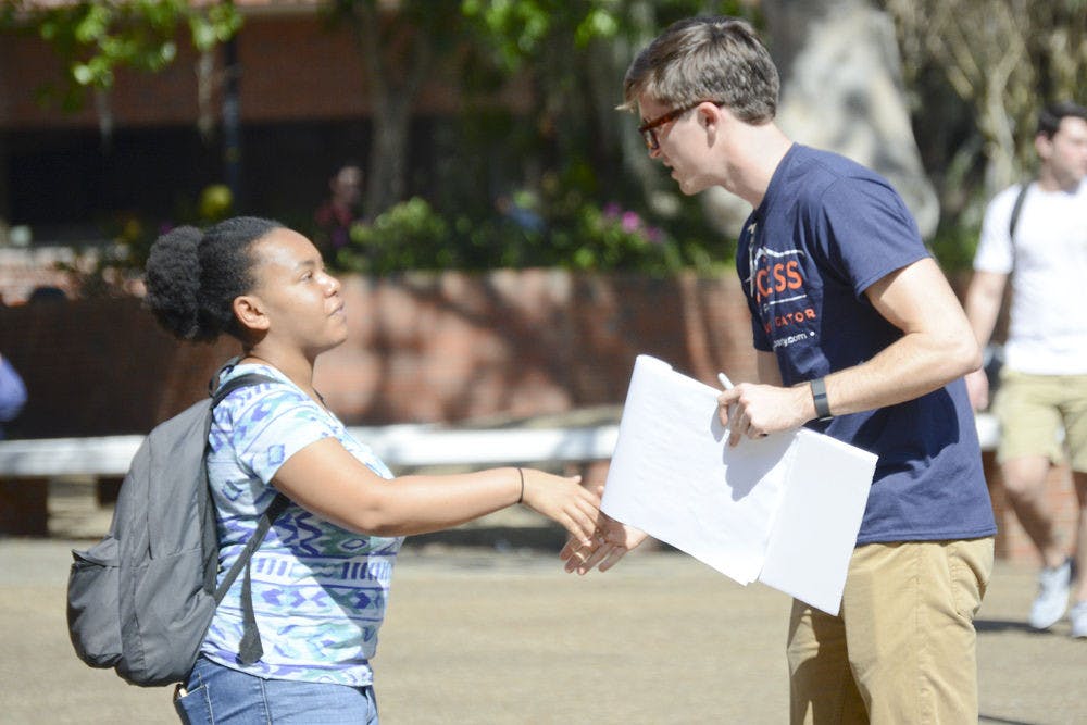 <p>Ashley Francois, a 20-year-old UF plant science junior, speaks with Ryan Wicks, a 20-year-old UF mechanical engineering junior running as an Access Party candidate for the College of Engineering Senate seat on Turlington Plaza on Tuesday. Francois said she wished there were more printing labs spread out around campus.</p>