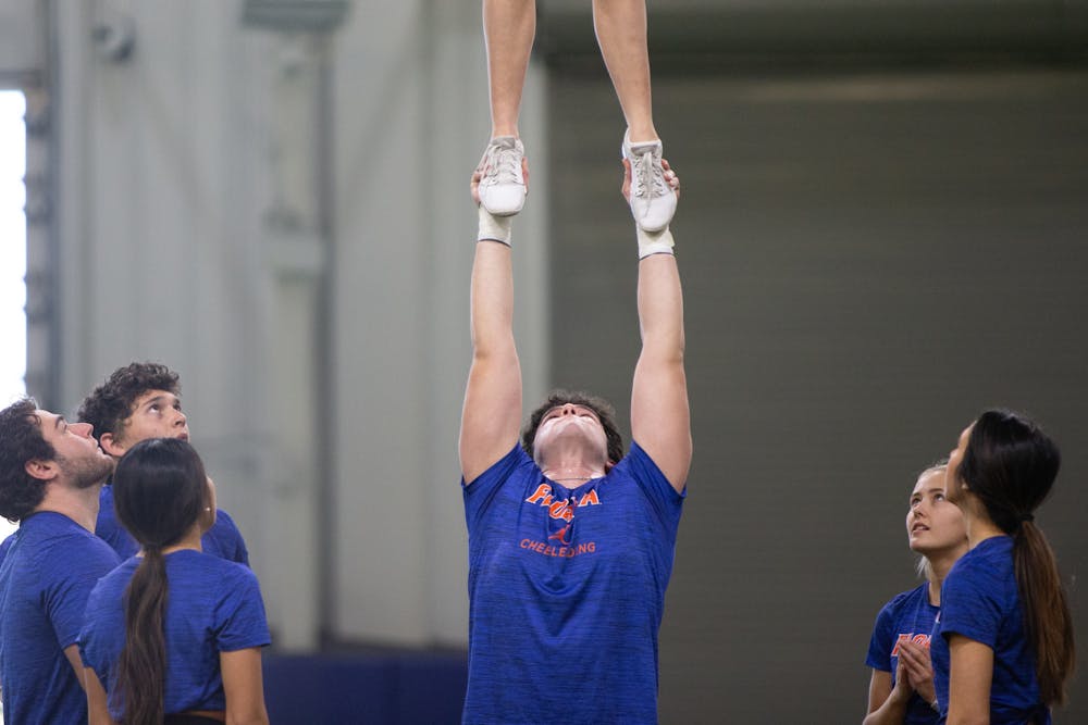 Florida Gators cheerleader Waleed Aref tosses Amrynne Hill during the team's practice on Tuesday, Feb. 20, 2024.