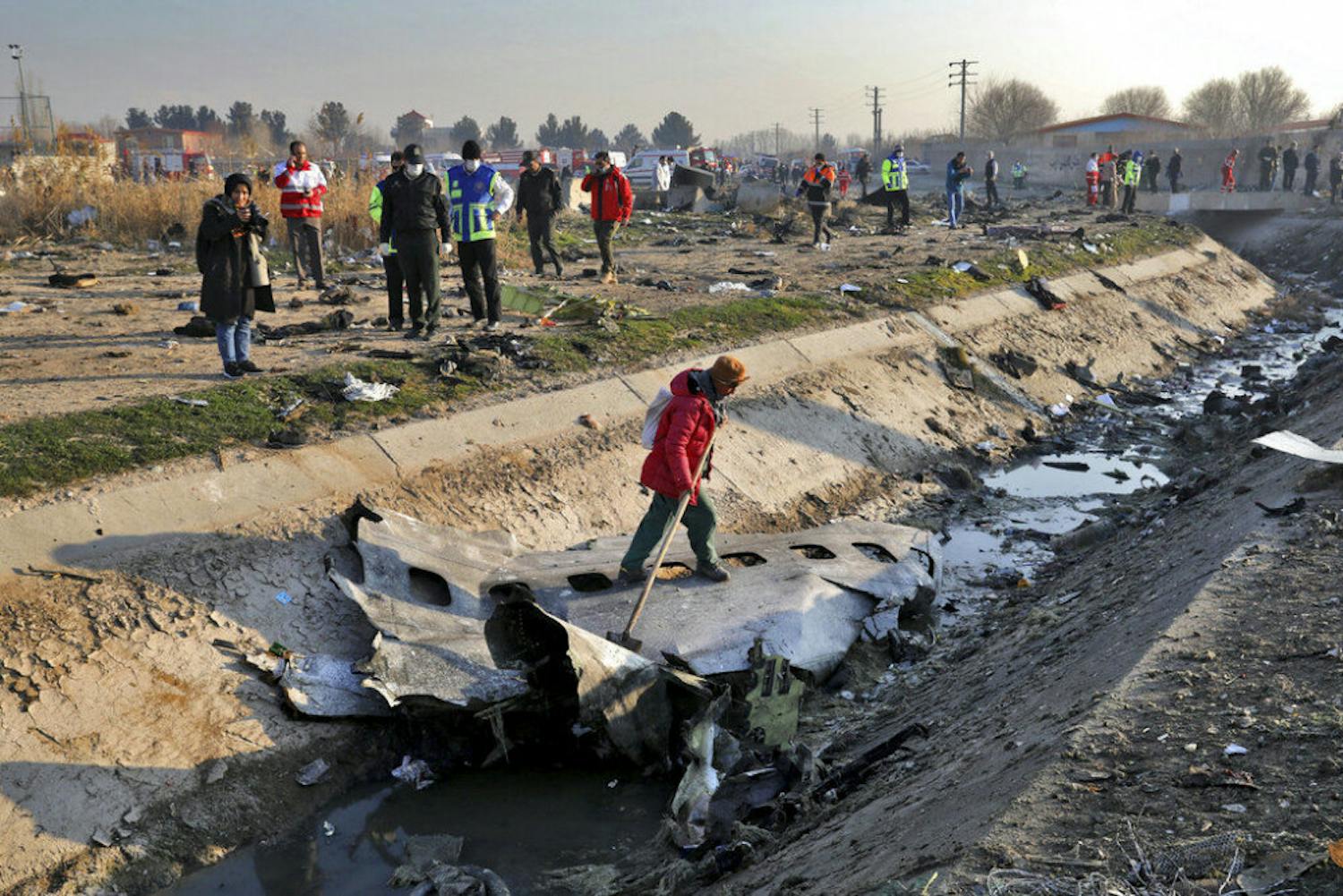 Rescue workers inspect the scene where a Ukrainian plane crashed in Shahedshahr, southwest of the capital Tehran, Iran, Wednesday, Jan. 8, 2020. A Ukrainian airplane with more than 170 people crashed on Wednesday shortly after takeoff from Tehran's main airport, killing all onboard. (AP Photo/Ebrahim Noroozi)