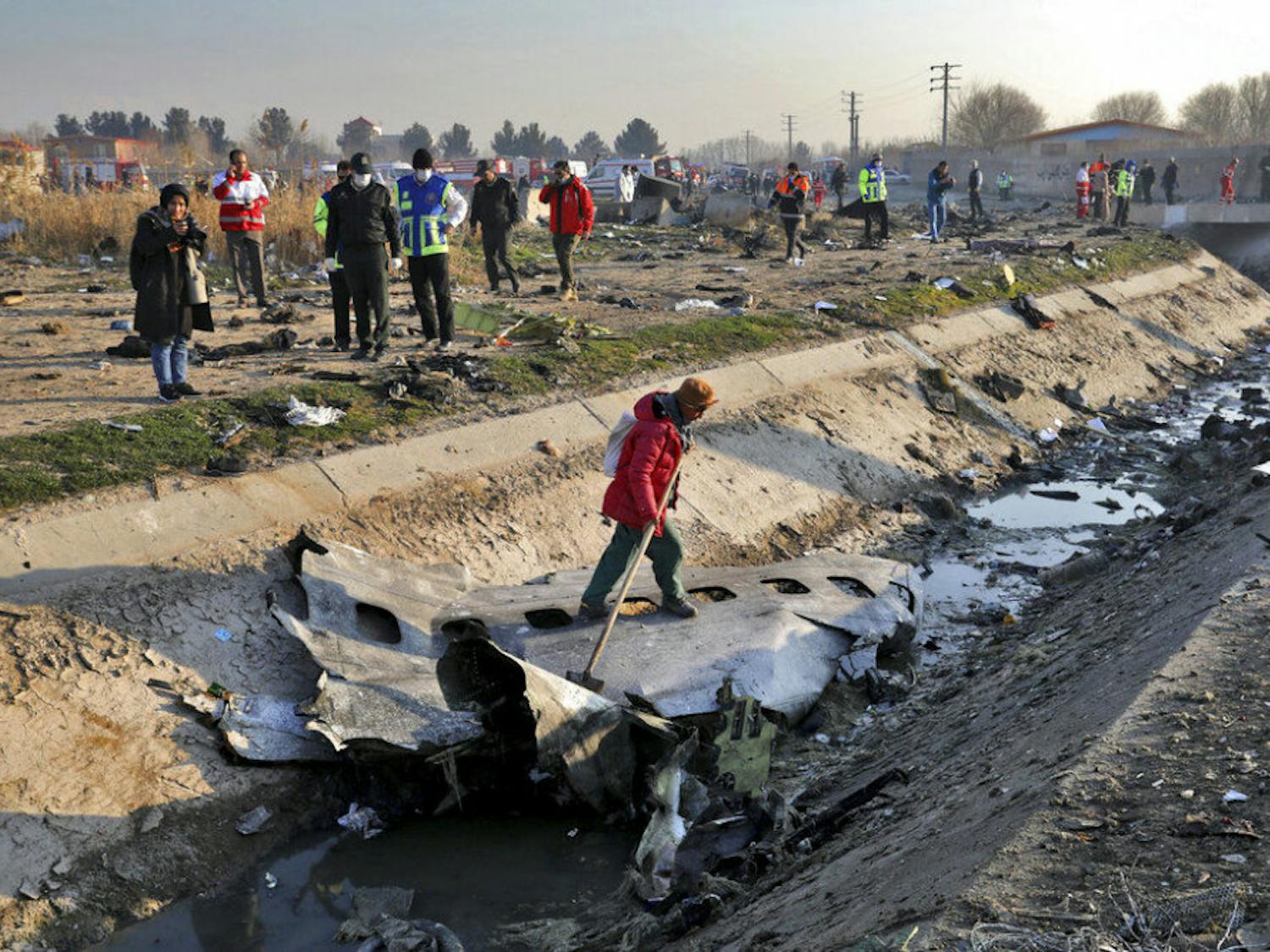 Rescue workers inspect the scene where a Ukrainian plane crashed in Shahedshahr, southwest of the capital Tehran, Iran, Wednesday, Jan. 8, 2020. A Ukrainian airplane with more than 170 people crashed on Wednesday shortly after takeoff from Tehran's main airport, killing all onboard. (AP Photo/Ebrahim Noroozi)