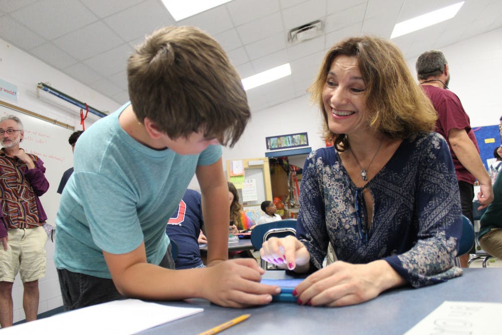 Amaya Hartel and her son Lander, 12, work together on an experiment about infrared consumption on mobile devices at the fourth annual Family Science and Robotics Night.
