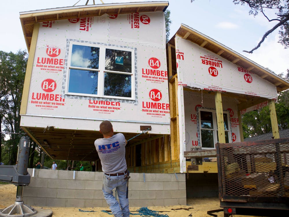 <p>Dawayne Bryan, a construction worker, pulls the modular home into place at High Springs on Thursday, June 8, 2023.<br/><br/></p>