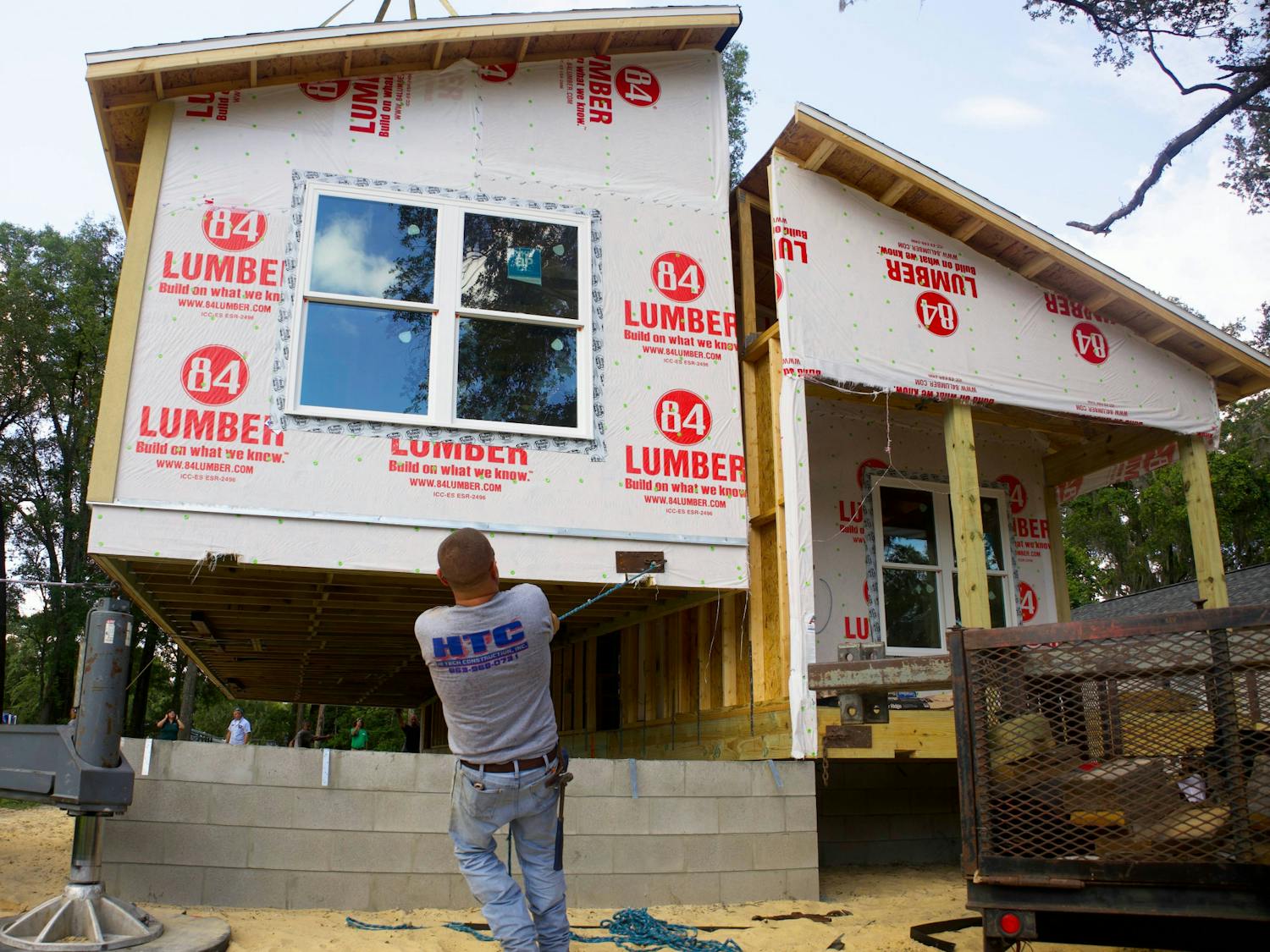 Dawayne Bryan, a construction worker, pulls the modular home into place at High Springs on Thursday, June 8, 2023.