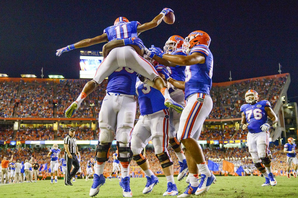 Demarcus Robinson (11) leaps into Roderick Johnson (55) to celebrate his TD catch in the third quarter of the Gators and Wildcats matchup in Ben Hill Griffin Stadium during UF's 36-30 triple overtime win on Sept. 13, 2014.