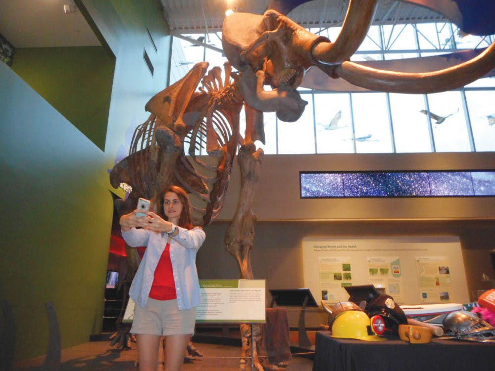 Jaime Benedict, a 20-year-old UF nursing junior, snaps a selfie in front of the mammoth skeleton at the Florida Museum of Natural History during “Museum Selfie Day.”
&nbsp;