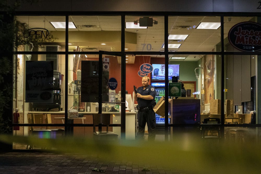 Investigator Matthew Sides prepares to examine the scene Sunday night  inside of the Jersey Mike’s in Butler Plaza where the wounded man was allegedly brought.