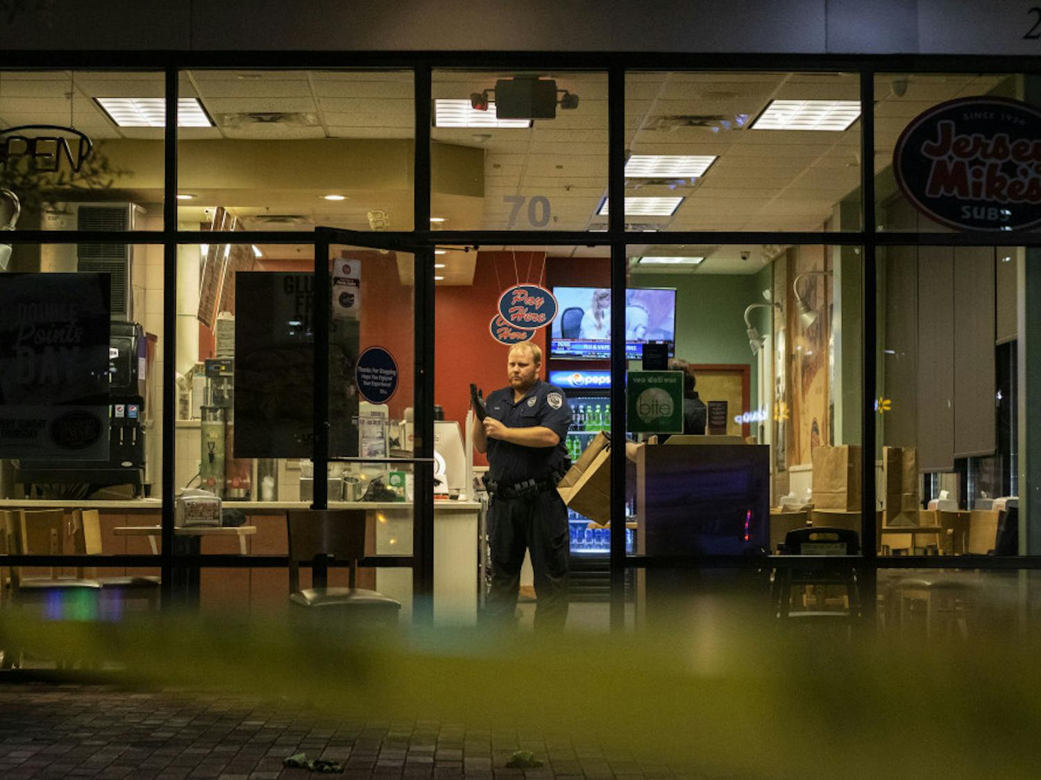 Investigator Matthew Sides prepares to examine the scene Sunday night inside of the Jersey Mike’s in Butler Plaza where the wounded man was allegedly brought.