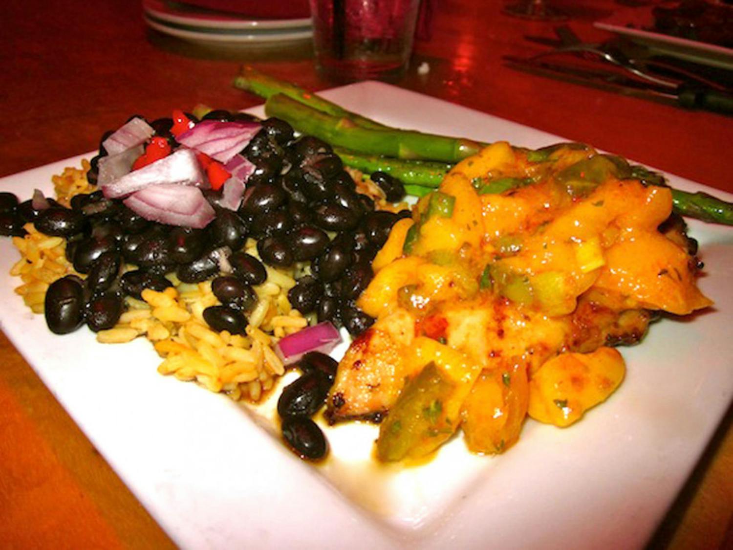 Pictured is a meal of chicken with spicy mango-jalapeño salsa, black beans over Spanish rice and asparagus from Emiliano’s.