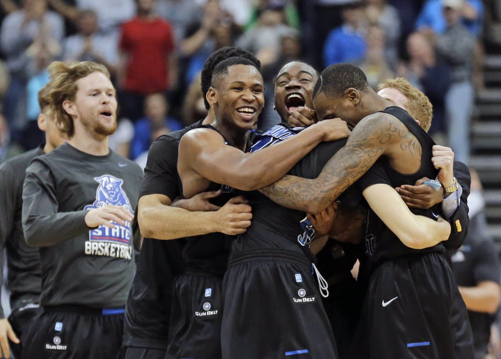 Georgia State players celebrate as they surround R.J. Hunter, center, after he made the game winning shot against Baylor an NCAA tournament second round college basketball game, Thursday, March 19, 2015, in Jacksonville, Fla. Georgia State won 57-56.