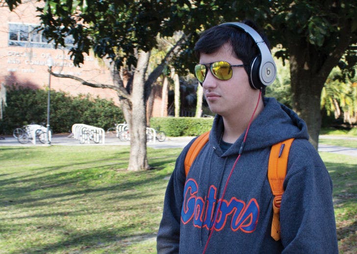 Eighteen-year-old UF engineering freshman Robert Morgado listens to music on his way to the Reitz Union on Tuesday afternoon. The Alachua County Library District has upped the size of its music collection by joining Freegal Music Service. Library users can download three free MP3 tracks per week.