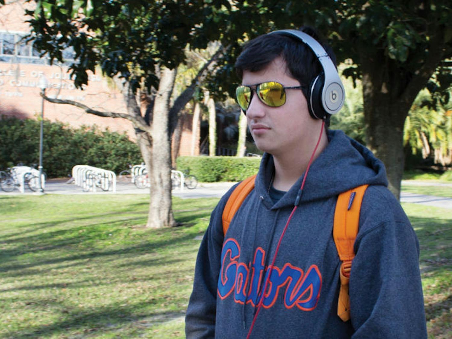 Eighteen-year-old UF engineering freshman Robert Morgado listens to music on his way to the Reitz Union on Tuesday afternoon. The Alachua County Library District has upped the size of its music collection by joining Freegal Music Service. Library users can download three free MP3 tracks per week.