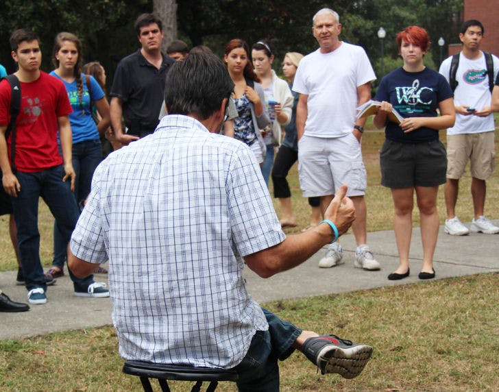 Preacher Tom Short talks to students about religion on the Plaza of the Americas on Monday afternoon. Students of different beliefs gathered to listen and debate.