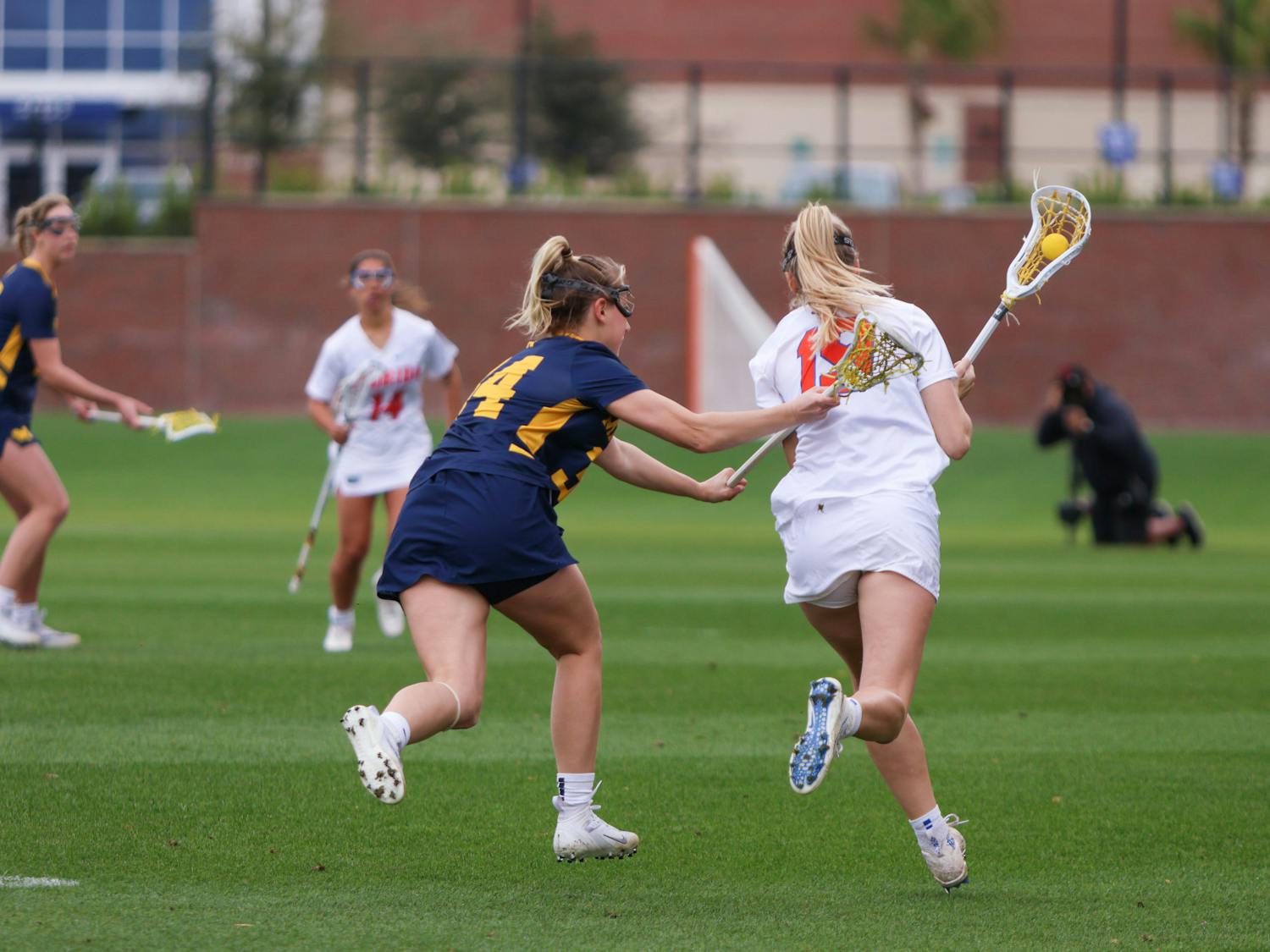 Florida attacker Maggi Hall runs with the ball in her crosse in the Gators' 17-8 win against the No. 18 Michigan Wolverines Sunday, Feb. 12, 2023.