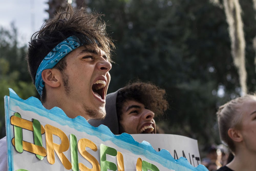 Michael Granto, a 17-year-old student at Santa Fe High, shouts Friday during the climate protest. Granto is in dual enrollment at Santa Fe College and is a member of Santa Fe Sustainability Club. Granto said he felt the need to attend the protest because “obviously the world is on fire”.