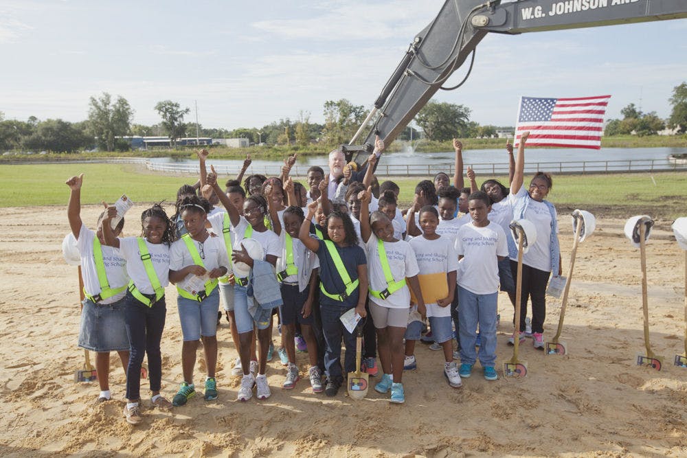 <p>Mayor Ed Braddy and a group of students from the Caring and Sharing Learning School stand on the site of the newly renovated Depot Park. “There will be a playground the size of a football field for you all to enjoy. We do these things for you and the whole community,” Braddy said during his speech.</p>