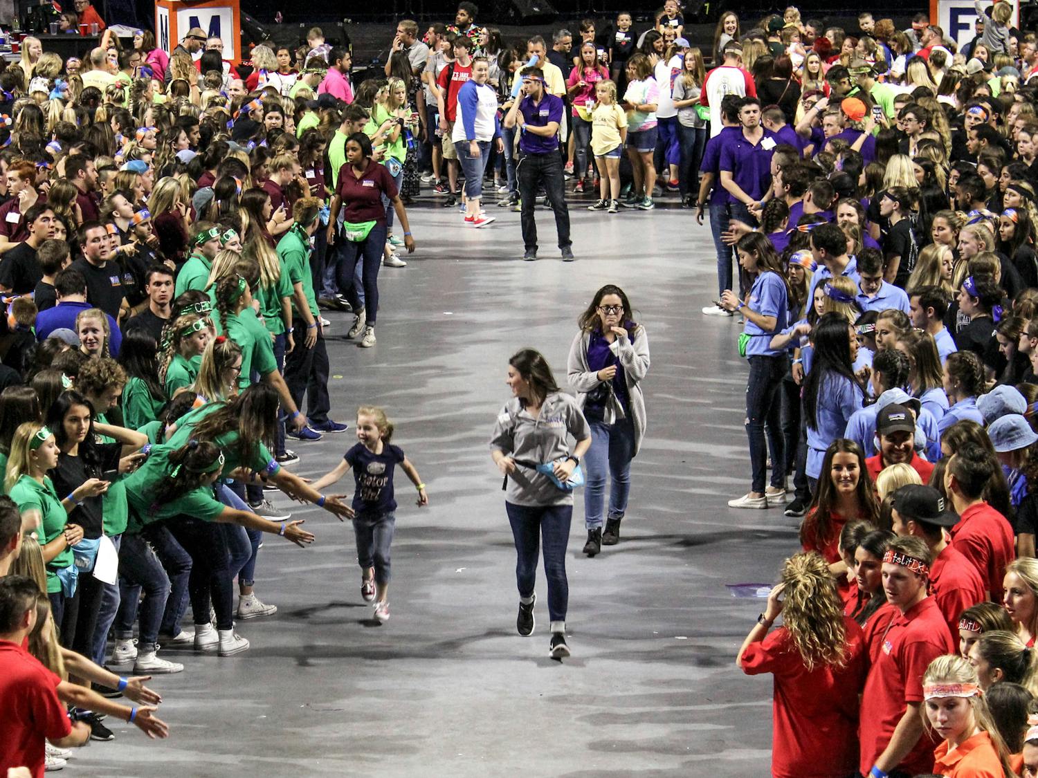 A child runs through the crowd of dancers during Dance Marathon at the O'Connell Center on Sunday. Dance Marathon is an event where volunteers must stay awake and on their feet for 26.2 hours. 