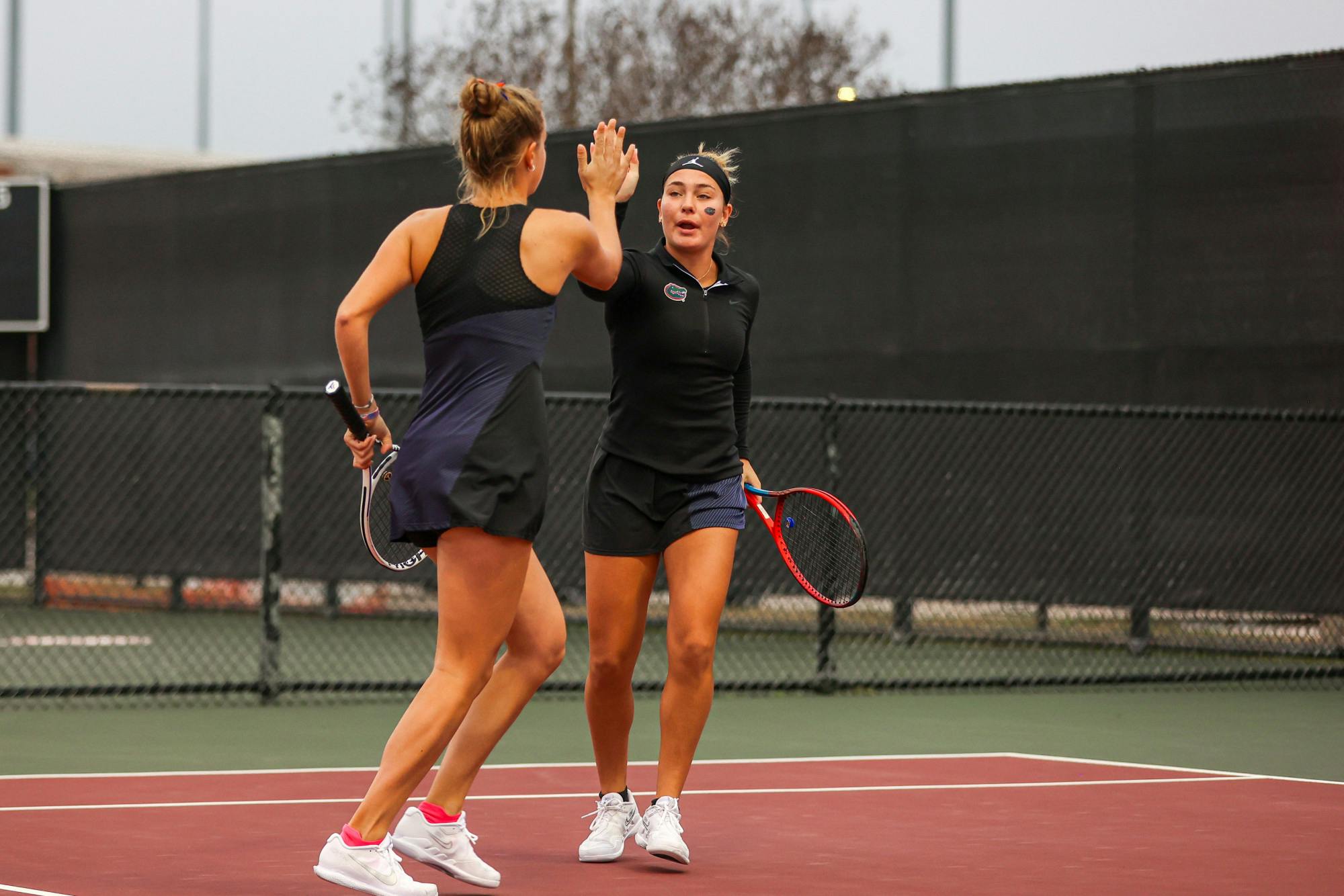 Gators women's tennis players Rachel Gailis and Bente Spee high-five during the Gators' match against the Texas A&M Aggies Monday, Jan. 30, 2023 / UAA Communications photo by Mario Terrana.