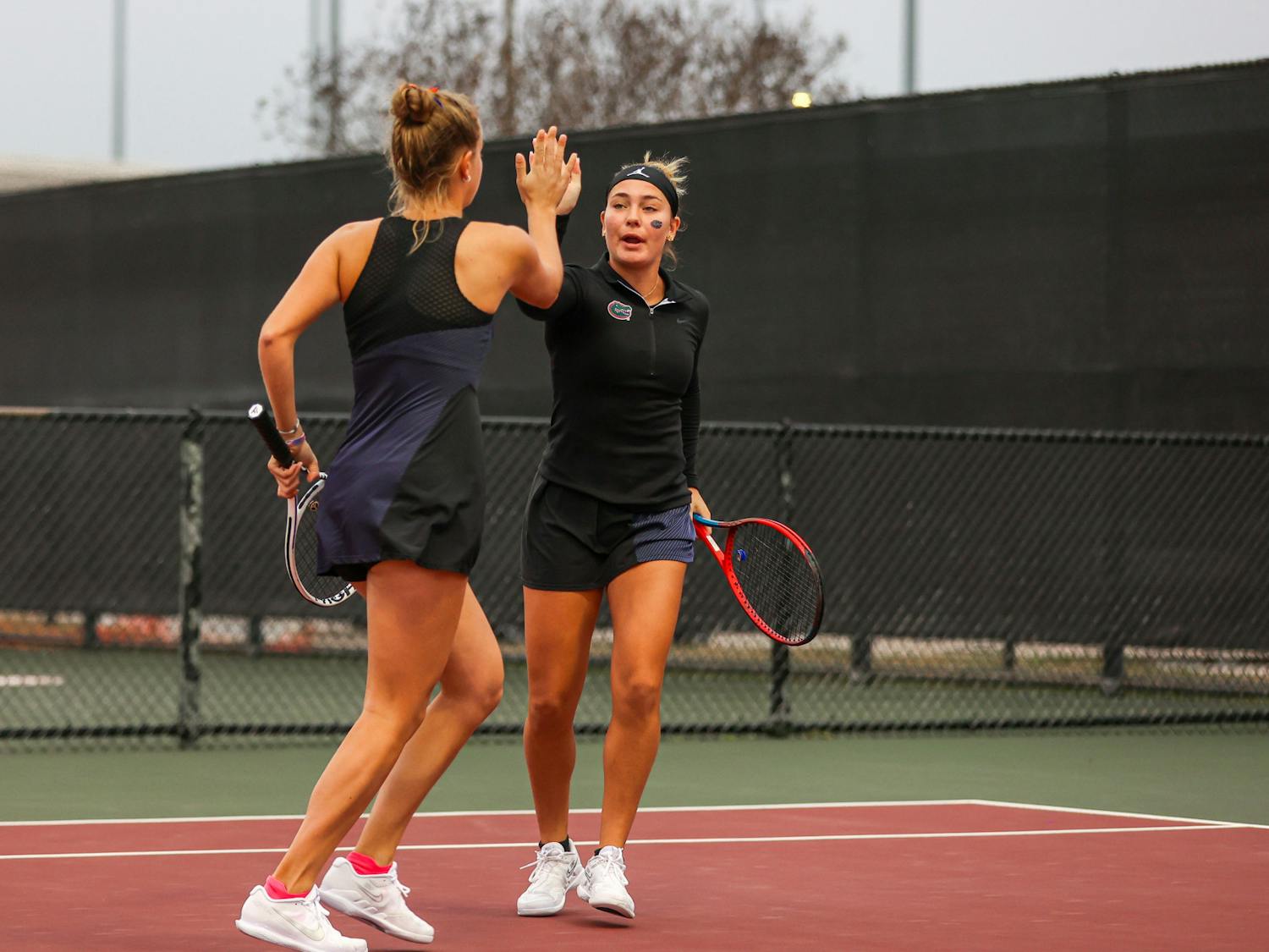 Gators women's tennis players Rachel Gailis and Bente Spee high-five during the Gators' match against the Texas A&M Aggies Monday, Jan. 30, 2023 / UAA Communications photo by Mario Terrana.