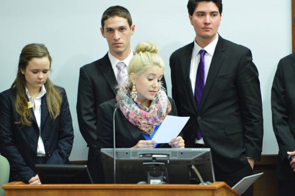 <p class="p1">Jessica Sullivan reads the bill that supports the Inter-Residence Hall Association’s expansion of printing services for residents, which now includes students in Broward Hall and the Murphree Area.</p>