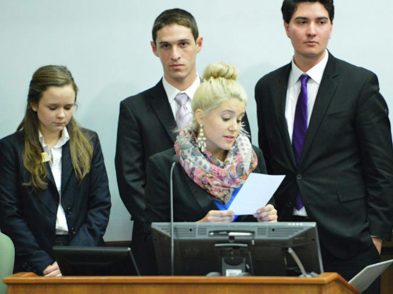 Jessica Sullivan reads the bill that supports the Inter-Residence Hall Association’s expansion of printing services for residents, which now includes students in Broward Hall and the Murphree Area.