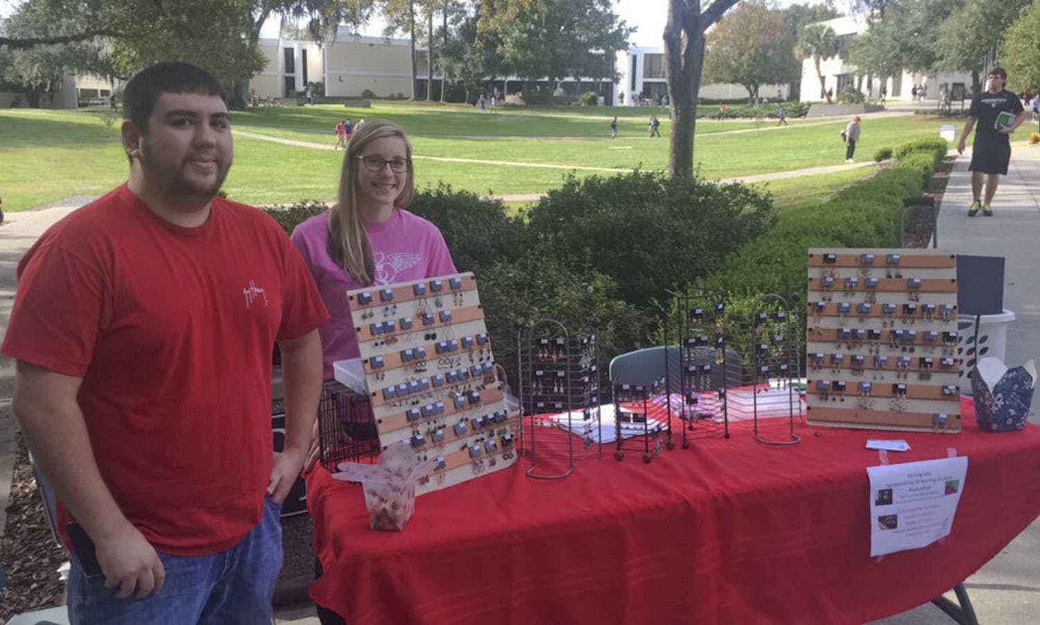 Tyler Welz (left), a 22-year-old Santa Fe nursing senior, and Caroline Lewis, a 21-year-old Santa Fe nursing senior, sell earrings on Nov. 30, 2015, outside Santa Fe’s food court to fund a trip to the Nursing Student Association's annual convention in Orlando. The earring sale ends today at 2 p.m.