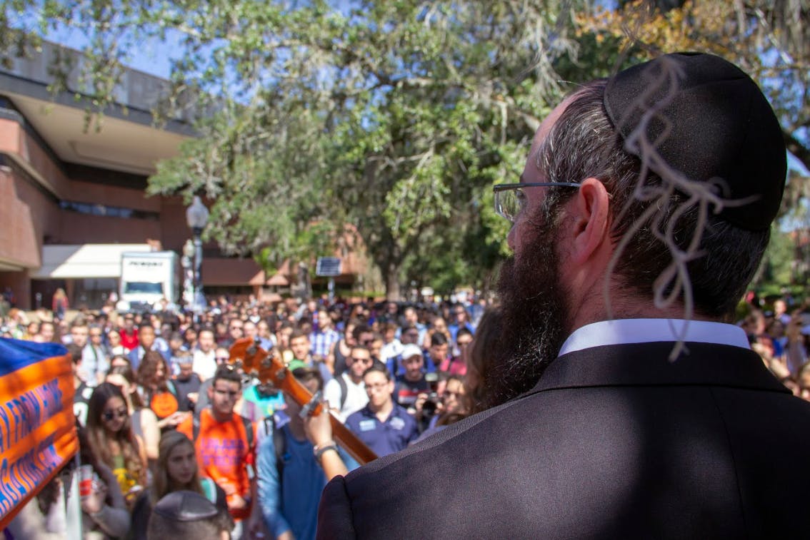 Rabbi Aron Notik stands over a crowd of hundreds Monday in Turlington Plaza during the candlelight vigil for the victims of the Tree of Life Synagogue. Eleven people were killed in the tragedy.