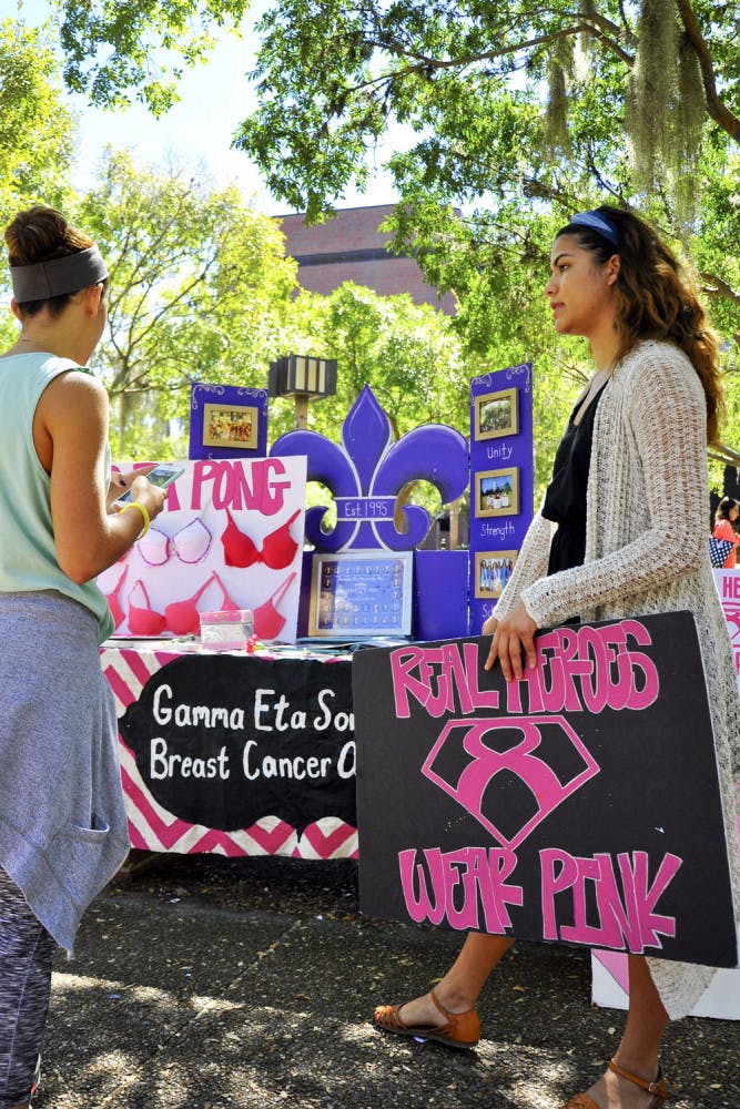 Gamma Eta sorority member Diana Rodriguez talks to Victoria Verdeja, a 21-year-old UF journalism student, about the organization’s Breast Cancer Awareness Week events. They have four events planned, including a benefit brunch Sunday called "Fasten Your Ribbon: The Breast is Yet to Come."