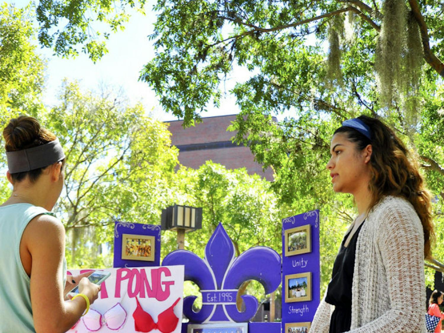 Gamma Eta sorority member Diana Rodriguez talks to Victoria Verdeja, a 21-year-old UF journalism student, about the organization’s Breast Cancer Awareness Week events. They have four events planned, including a benefit brunch Sunday called "Fasten Your Ribbon: The Breast is Yet to Come."