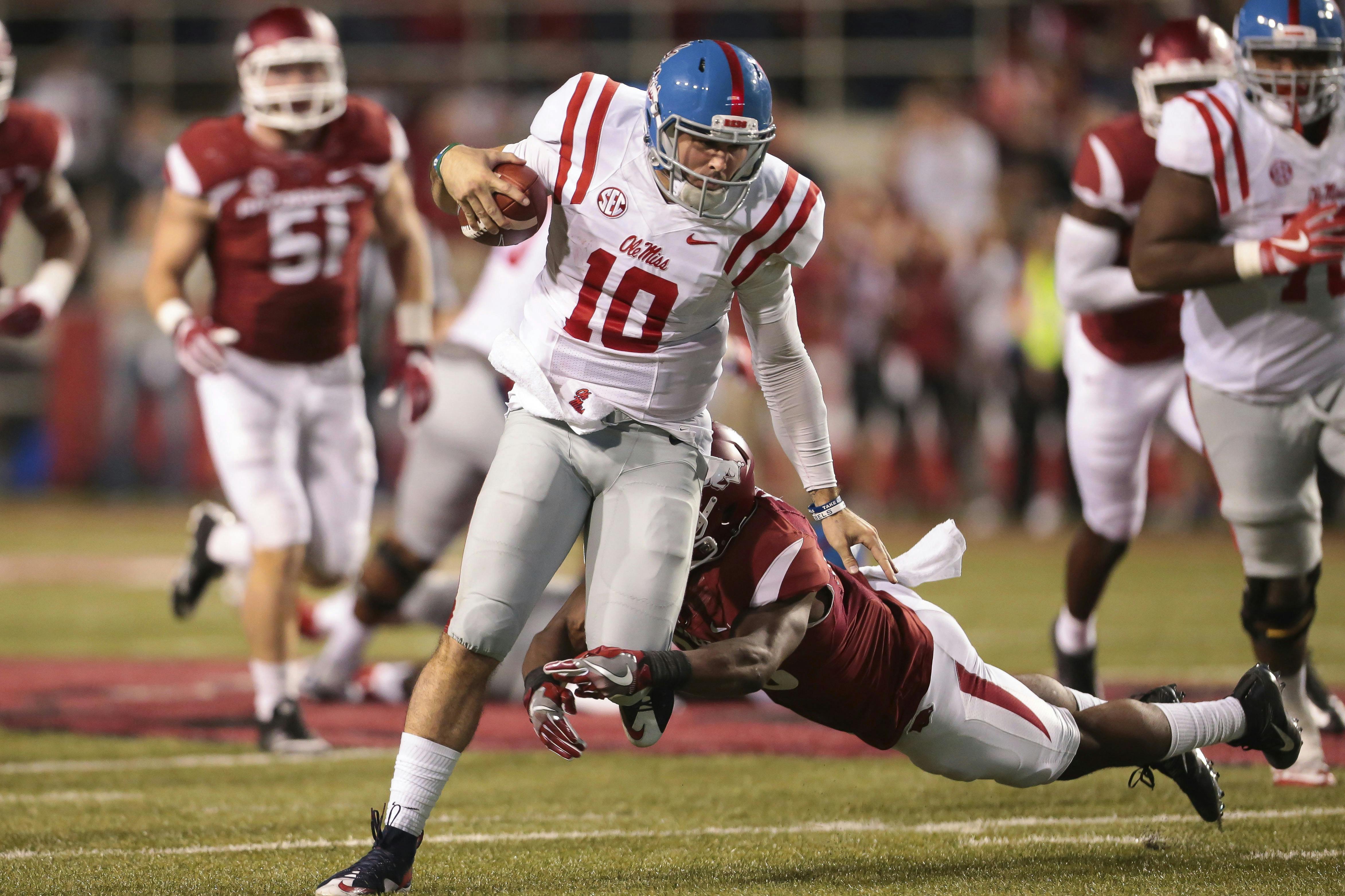 Mississippi's quarterback Chad Kelly (10) tries to run through the tackle of Arkansas' defensive back Josh Liddell (28) in the second half of an NCAA football game Saturday, Oct. 15, 2016, in Fayetteville, Ark. Arkansas beat Mississippi 34-30. (AP Photo/Chris Brashers)