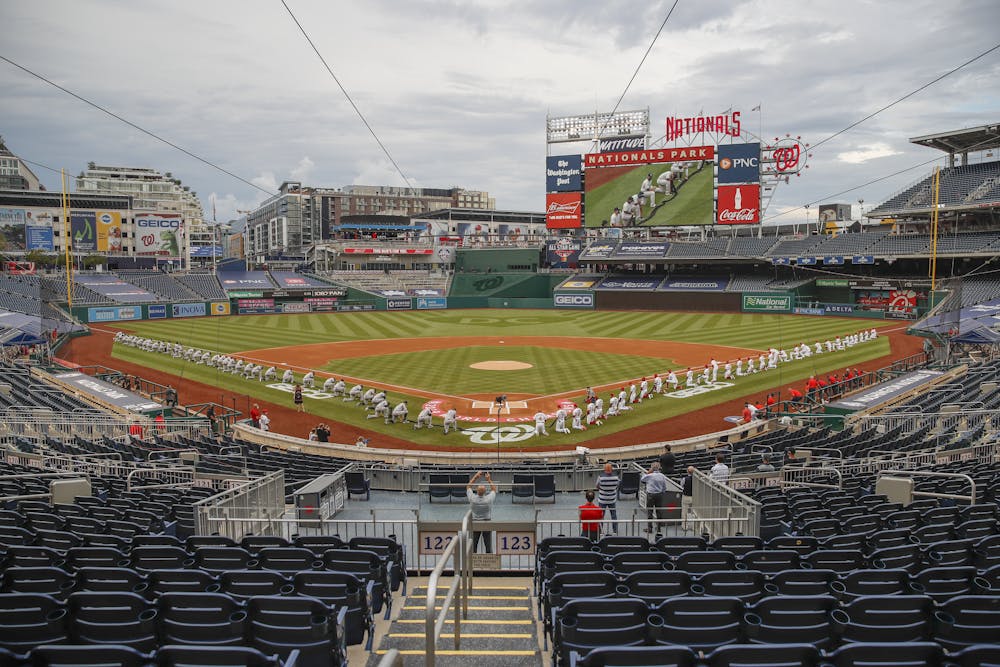 <p>The New York Yankees and the Washington Nationals kneel while holding a black ribbon to honor Black Lives Matter before playing an opening day baseball game at Nationals Park, Thursday, July 23, 2020, in Washington. before the start of the first inning of an opening day baseball game at Nationals Park, Thursday, July 23, 2020, in Washington. (AP Photo/Alex Brandon)</p>