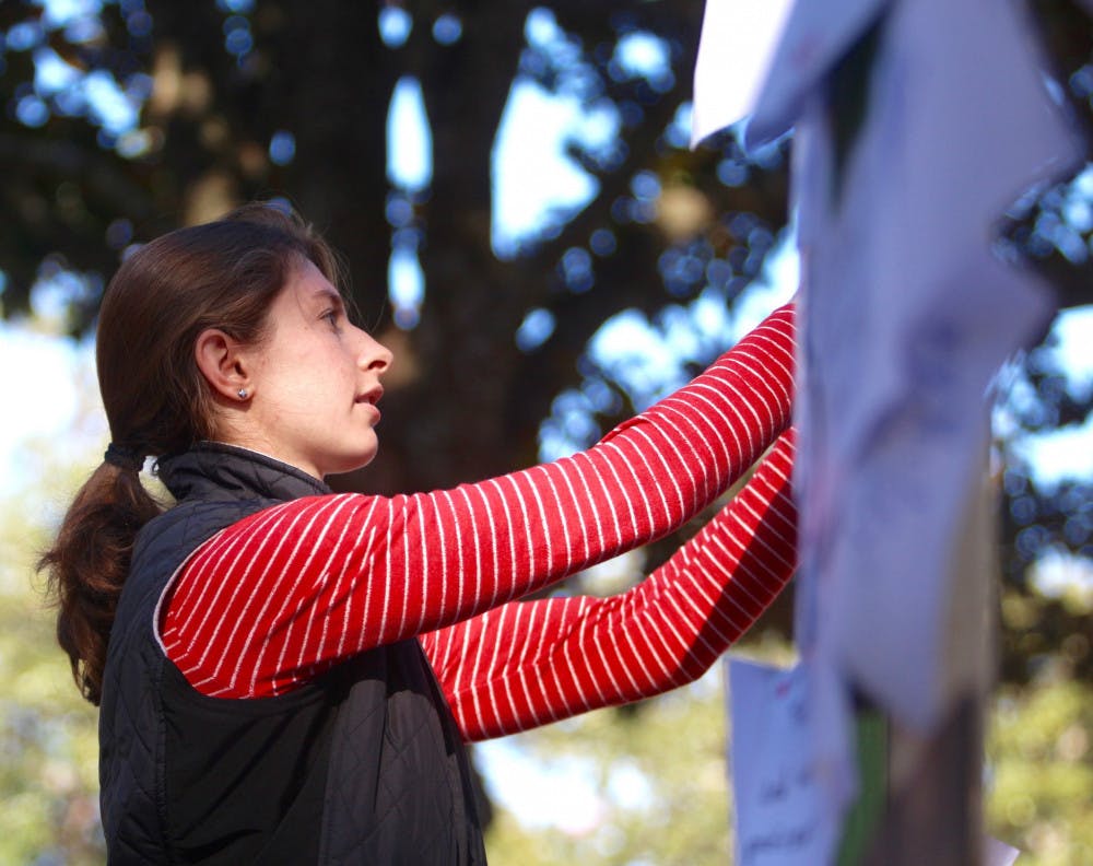 Elena Rubino, a 26-year-old doctoral candidate, posts a graduate student’s complaint about what she had to give up in order to pay her graduate school fees on an alligator-shaped board on the Plaza of the Americas as part of the Graduate Assistants United’s Chomp Out Fees campaign. Rubino, who studies in the UF School of Natural Resources and Environment as well as in the UF Department of Wildlife Ecology and Conservation, said she can’t go home to New Jersey for Thanksgiving because she is tight for money.