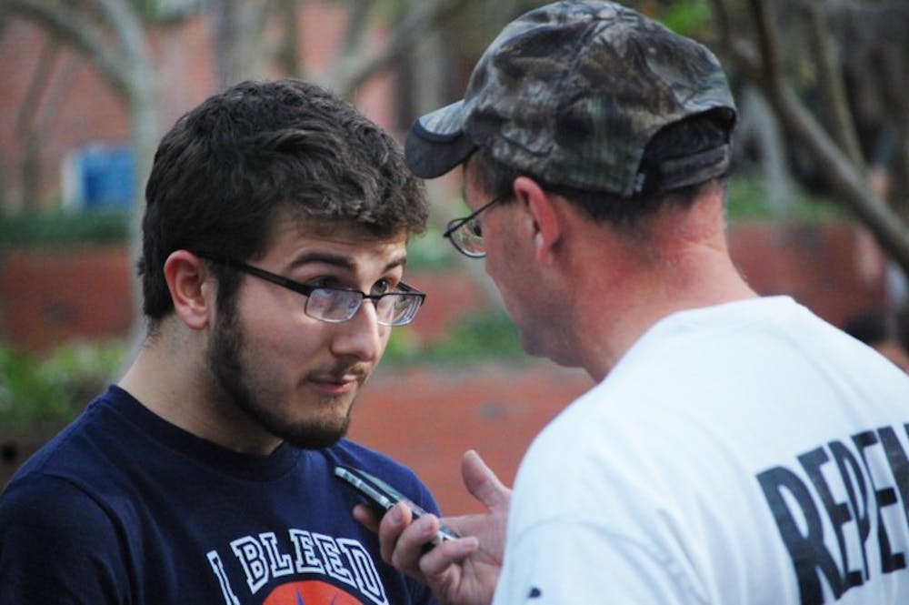 <p>Christian Chessman, 19, and Matt Bourgault, a self-proclaimed evangelical preacher, engage in an altercation on Turlington Plaza on Thursday afternoon.</p>