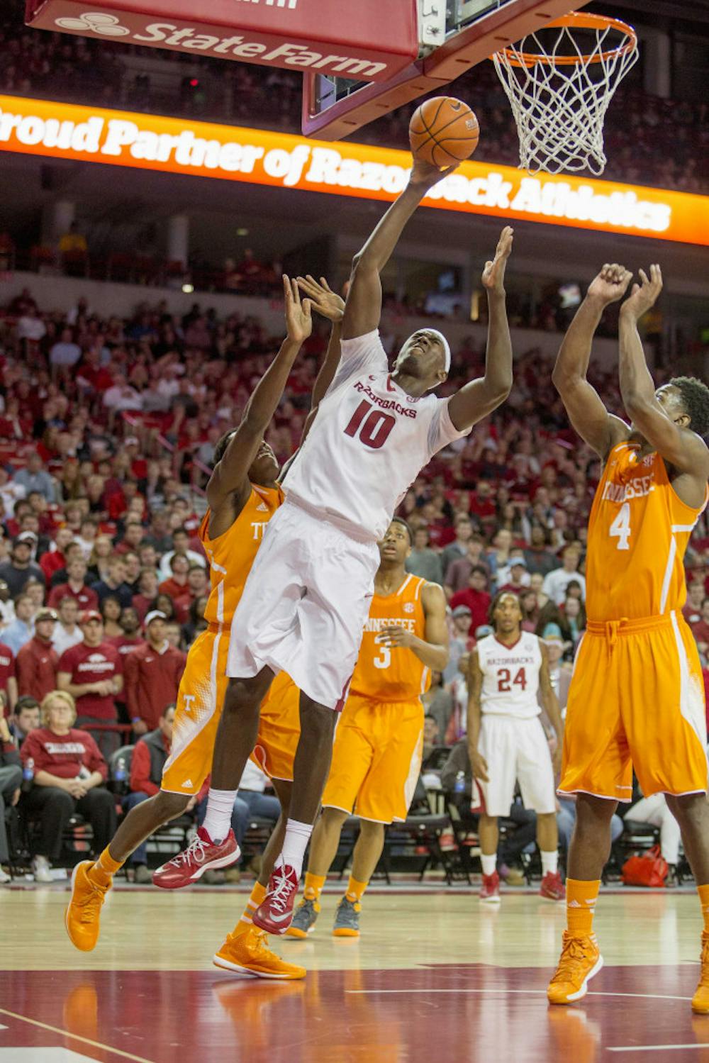 <p>Arkansas forward Bobby Portis, center, shoots a layup as Tennessee forward Armani Moore, right, guards during the second half of an NCAA college basketball game on Tuesday, Jan. 27, 2015, in Fayetteville, Ark. Arkansas defeated Tennessee 69-64.</p>