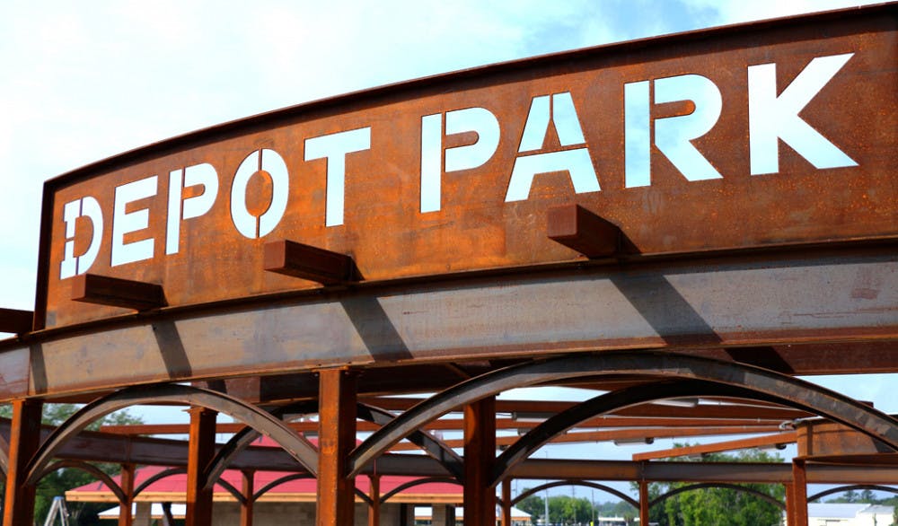 <p>A rusted metal sign marking the entrance to Depot Park, which is being constructed in dedication to Gainesville’s industrial sector, evokes the history behind the land in downtown that used to be used as a railroad station.</p>