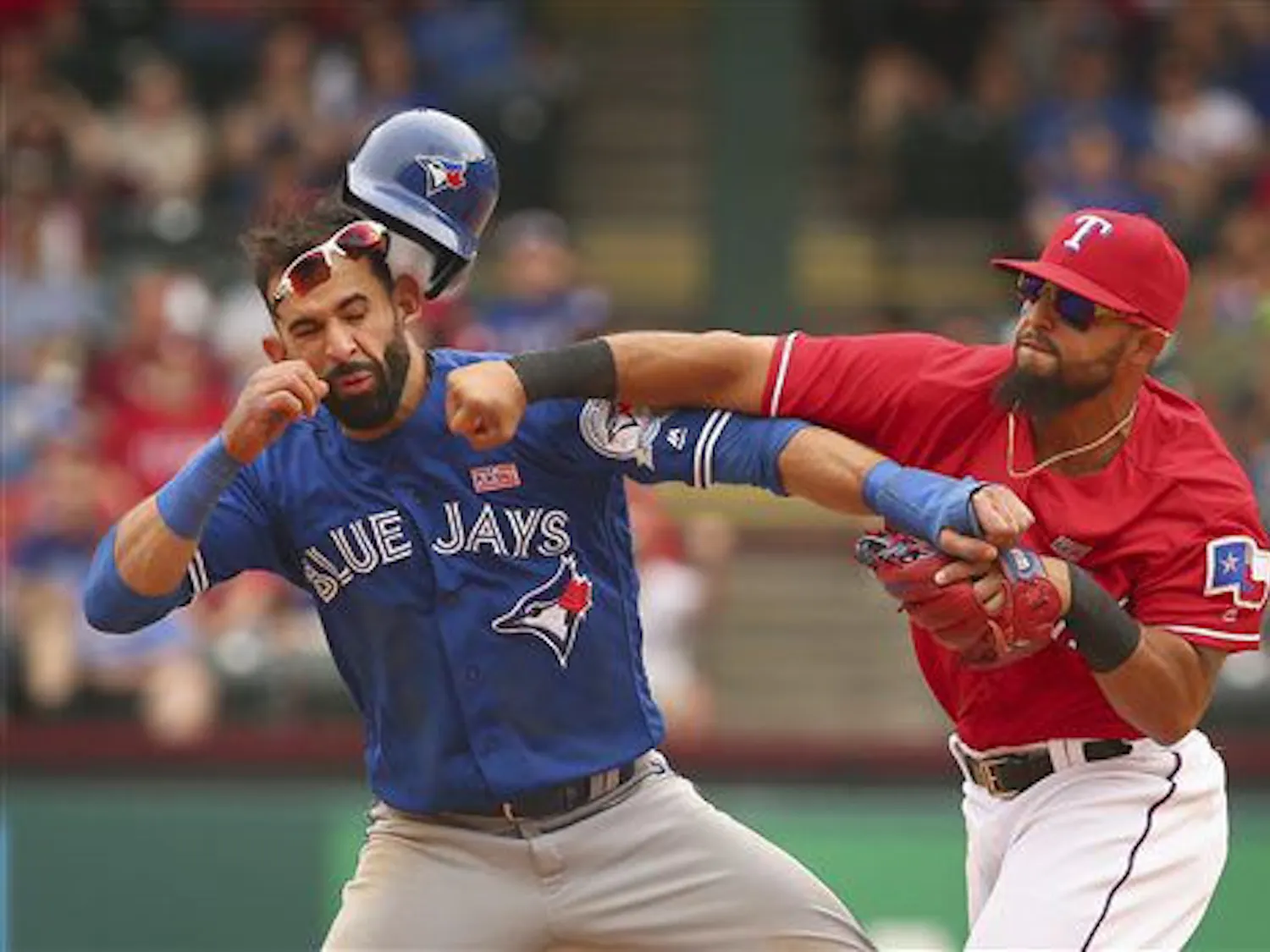 Toronto Blue Jays Jose Bautista (19) gets hit by Texas Rangers second baseman Rougned Odor (12) after Bautista slid into second in the eighth inning of a baseball game at Globe Life Park in Arlington, Texas, Sunday May 15, 2016. (Richard W. Rodriguez/Star-Telegram via AP)