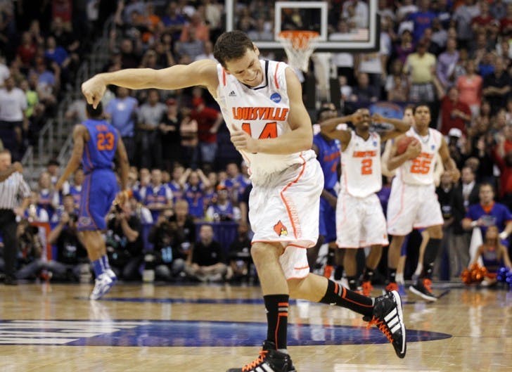Louisville’s Kyle Kuric punches the air in celebration after the Cardinals overcame an 11-point deficit in the final nine minutes to hand the Gators their second consecutive Elite Eight loss.