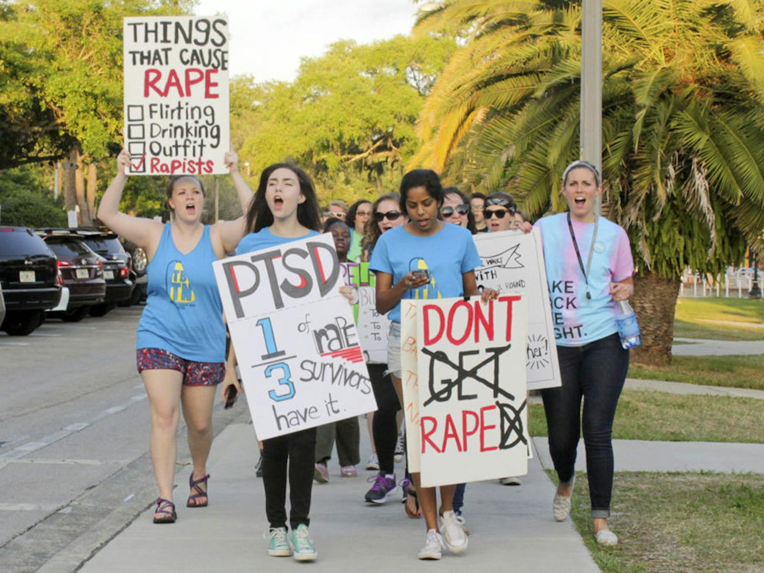 Madeleine Hill, Alissa Kotranza and Kriti Vedhanayagan, all UF students, and UFPD victim advocate Anne Carper march west on Inner Road in the Take Back the Night march to end sexual violence. “Yes means yes. No means no. Whatever we wear, wherever we go,” they chanted.