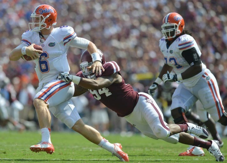 Gators sophomore quarterback Jeff Driskel tries to evade Texas A&amp;M defensive lineman Damontre Moore at Kyle Field Saturday. UF defeated the Aggies despite surrendering eight sacks.