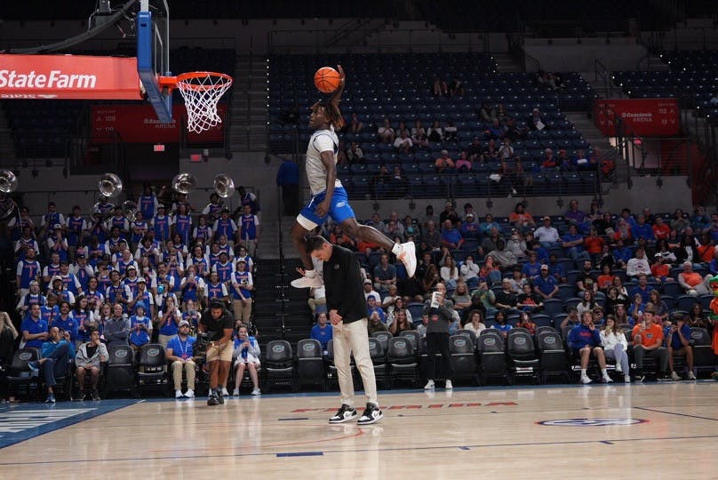Sophomore guard Denzel Aberdeen dunks the ball over the head of UF head coach Todd Golden in the Gators' Orange & Blue scrimmage on Thursday, Nov. 3, 2023.
