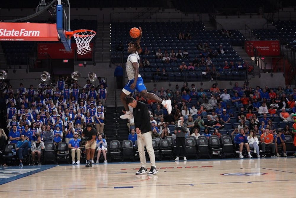 Sophomore guard Denzel Aberdeen dunks the ball over the head of UF head coach Todd Golden in the Gators' Orange & Blue scrimmage on Thursday, Nov. 3, 2023.