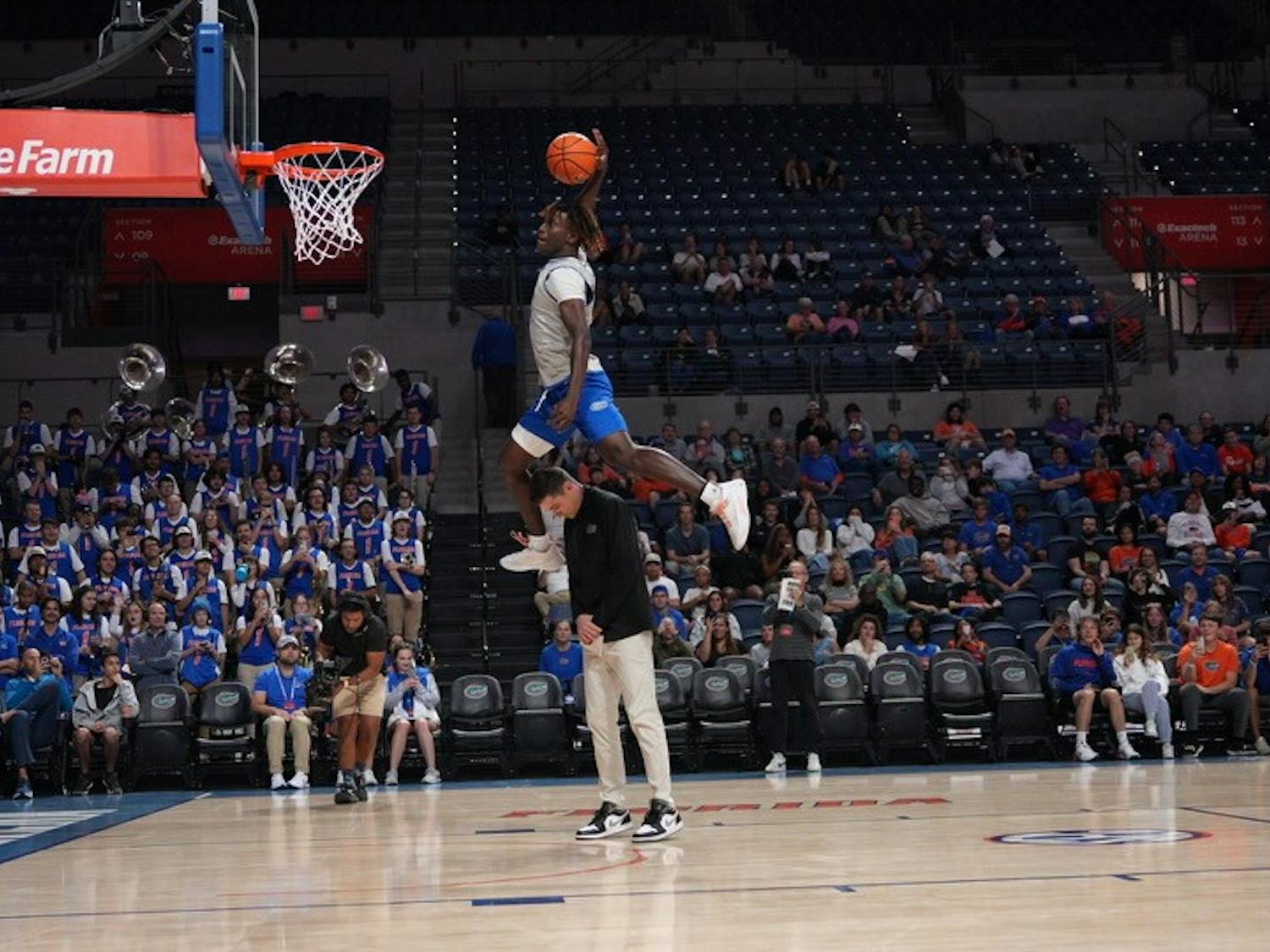 Sophomore guard Denzel Aberdeen dunks the ball over the head of UF head coach Todd Golden in the Gators' Orange & Blue scrimmage on Thursday, Nov. 3, 2023.