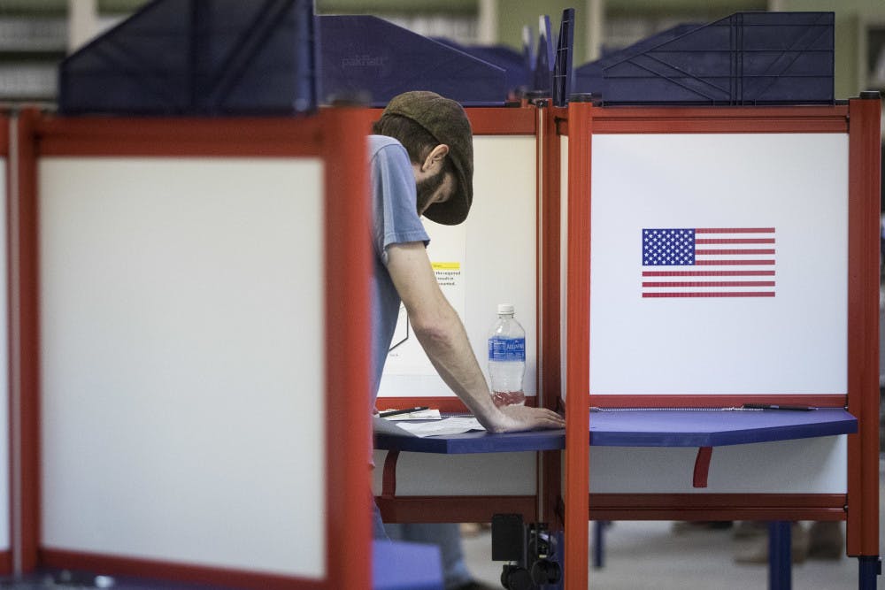 A voter reads his ballot at the Hamilton County Board of Elections as early voting begins statewide, Wednesday, Oct. 12, 2016, in Cincinnati.