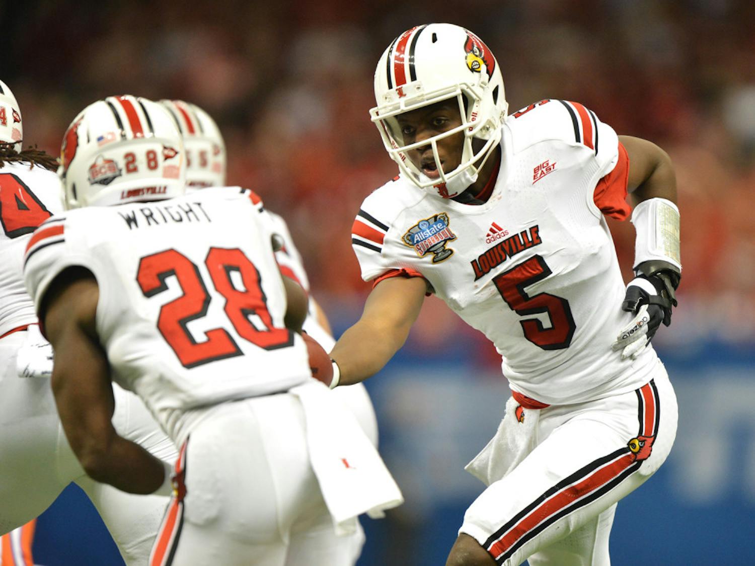 Louisville quarterback Teddy Bridgewater hands the ball off to running back Jeremy Wright during the Allstate Sugar Bowl in New Orleans, La.