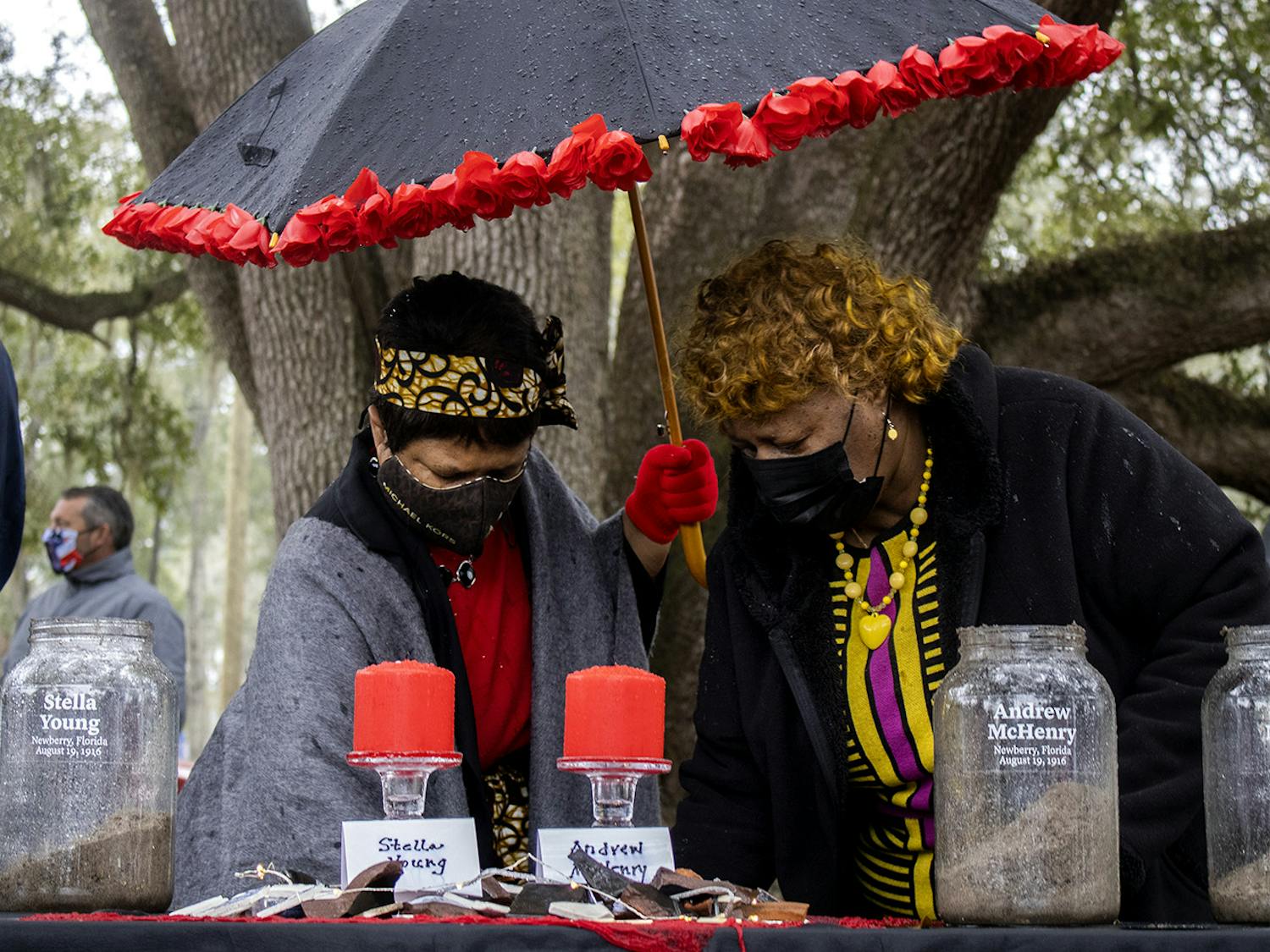Gail K. Watson (left) and Brenda Whitfield (right) scoop dirt into glass jars at the soil ceremony for the Newberry Six on Friday, Feb. 5, 2021. Whitfield spoke during the ceremony before the crowd began adding earth to the containers.