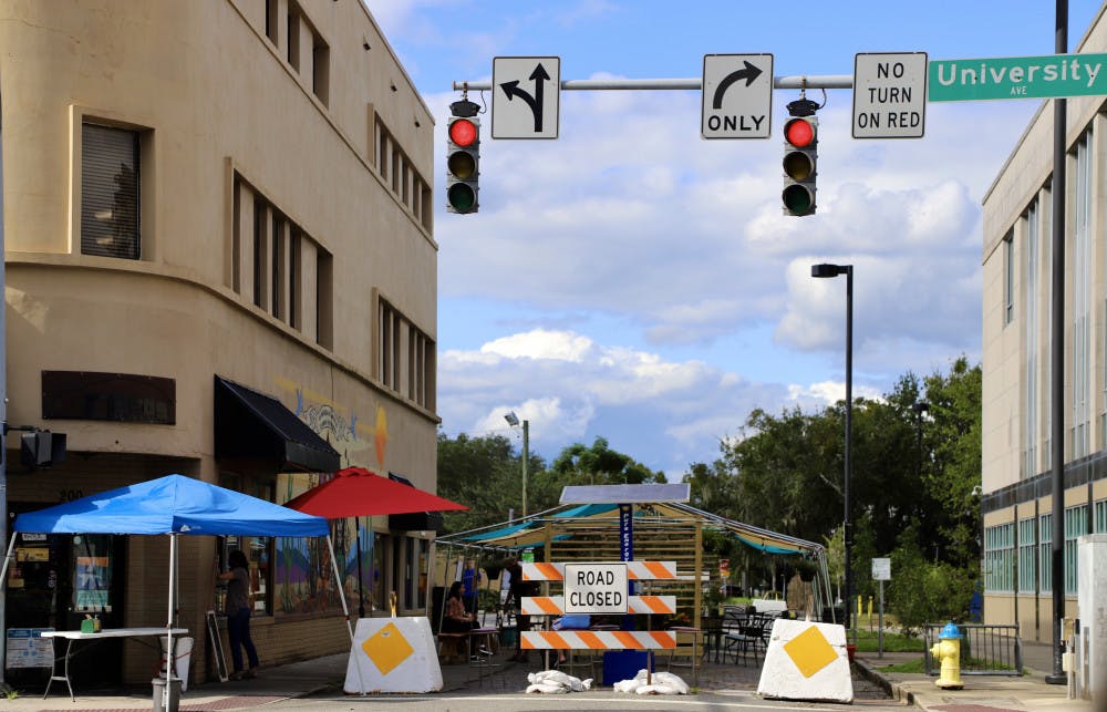 Diners choose to eat outside on the covered street patio outside Flaco’s Cuban Bakery on Sept. 18, 2020. Flaco’s is one of multiple downtown Gainesville restaurants that have participated in the Streatery GNV initiative, which inspires restaurants to block off access roads to create outside dining options for guests.